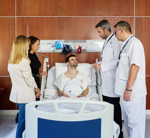 Médicos conversando con un paciente internado acompañado por sus familiares